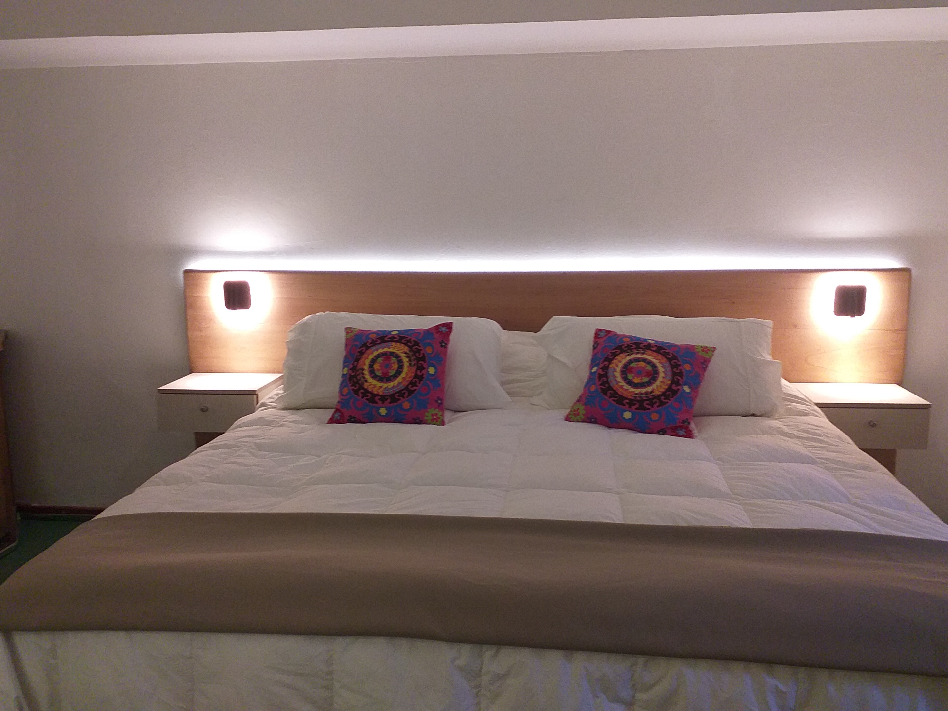 Cama matrimonial del estudio familiar de Casaquince con luces cálidas