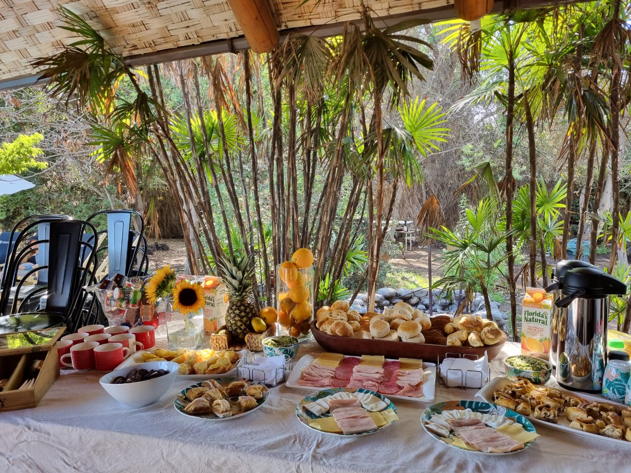 Desayuno corporativo bajo el quincho rodeado de palmeras